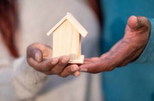 Homeowner reviewing mortgage refix options while holding a small house model