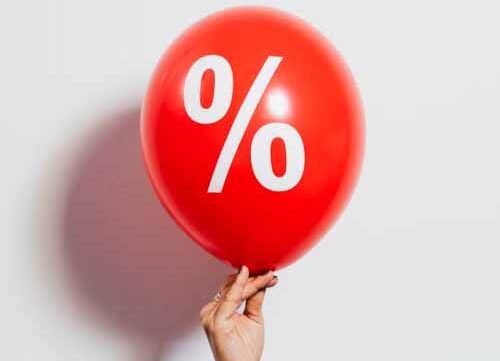 Red percentage symbol balloon representing changing interest rates and mortgage costs in New Zealand