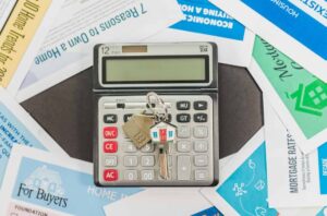 House key on a calculator representing mortgage repayments and financial protection if a homeowner dies or cannot work
