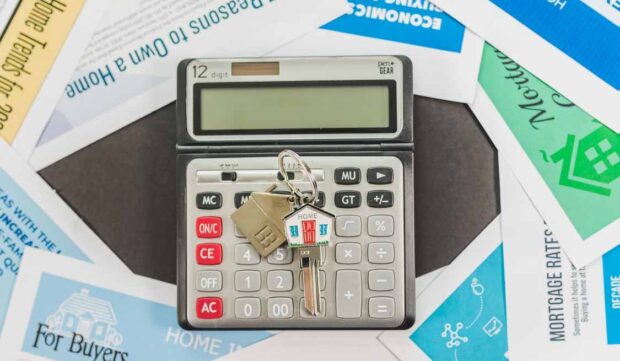 House key on a calculator representing mortgage repayments and financial protection if a homeowner dies or cannot work